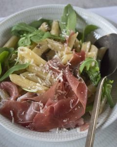 Penne met truffelroomsaus, rucola en parmaham