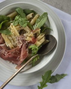 Penne met truffelroomsaus, rucola en parmaham