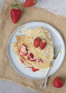 Crêpes met aardbeien, witte chocolade en geschaafde amandelen