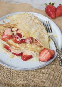 Crêpes met aardbeien, witte chocolade en geschaafde amandelen
