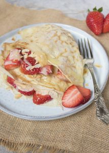 Crêpes met aardbeien, witte chocolade en geschaafde amandelen