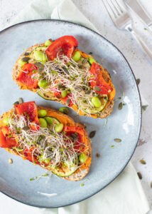 Toast met paprika hummus, gegrilde groenten, sojabonen & pompoenpitten