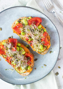 Toast met paprika hummus, gegrilde groenten, sojabonen & pompoenpitten