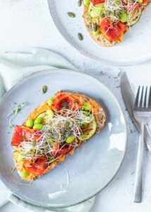 Toast met paprika hummus, gegrilde groenten, sojabonen & pompoenpitten
