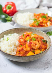 Wokgarnalen in tomatensaus met paprika, courgette & rijst