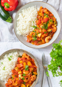 Wokgarnalen in tomatensaus met paprika, courgette & rijst